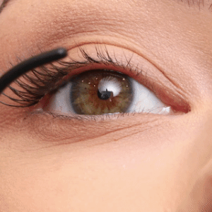 Primer plano de una modelo aplicando las pestañas en racimo